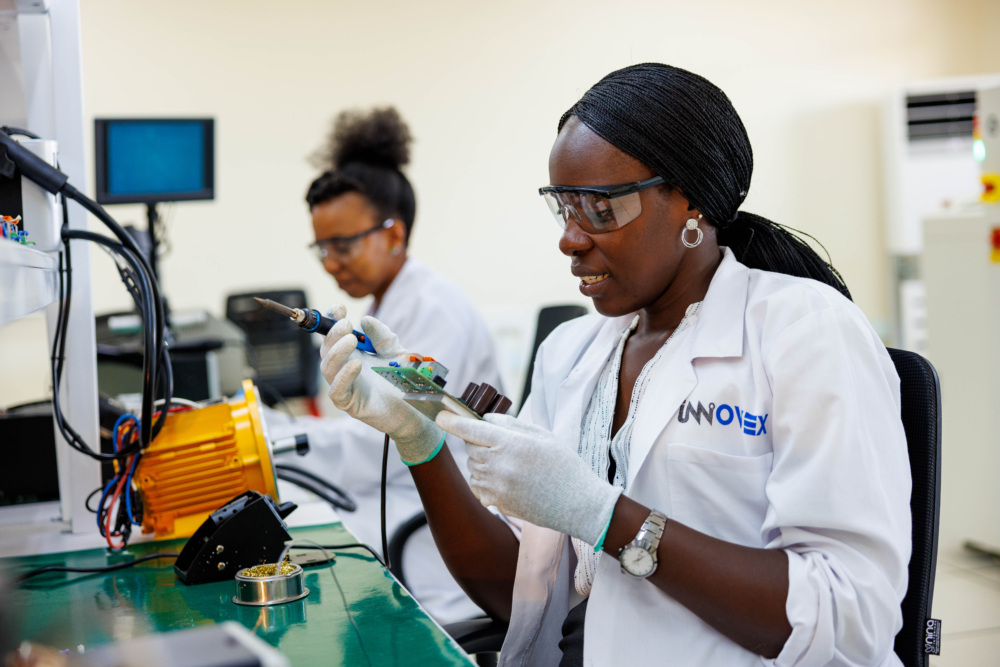A person conducting research and development in remote monitoring, their lab coat reads Innovex