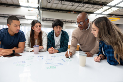 Teacher giving tutoring a group of students at a community college